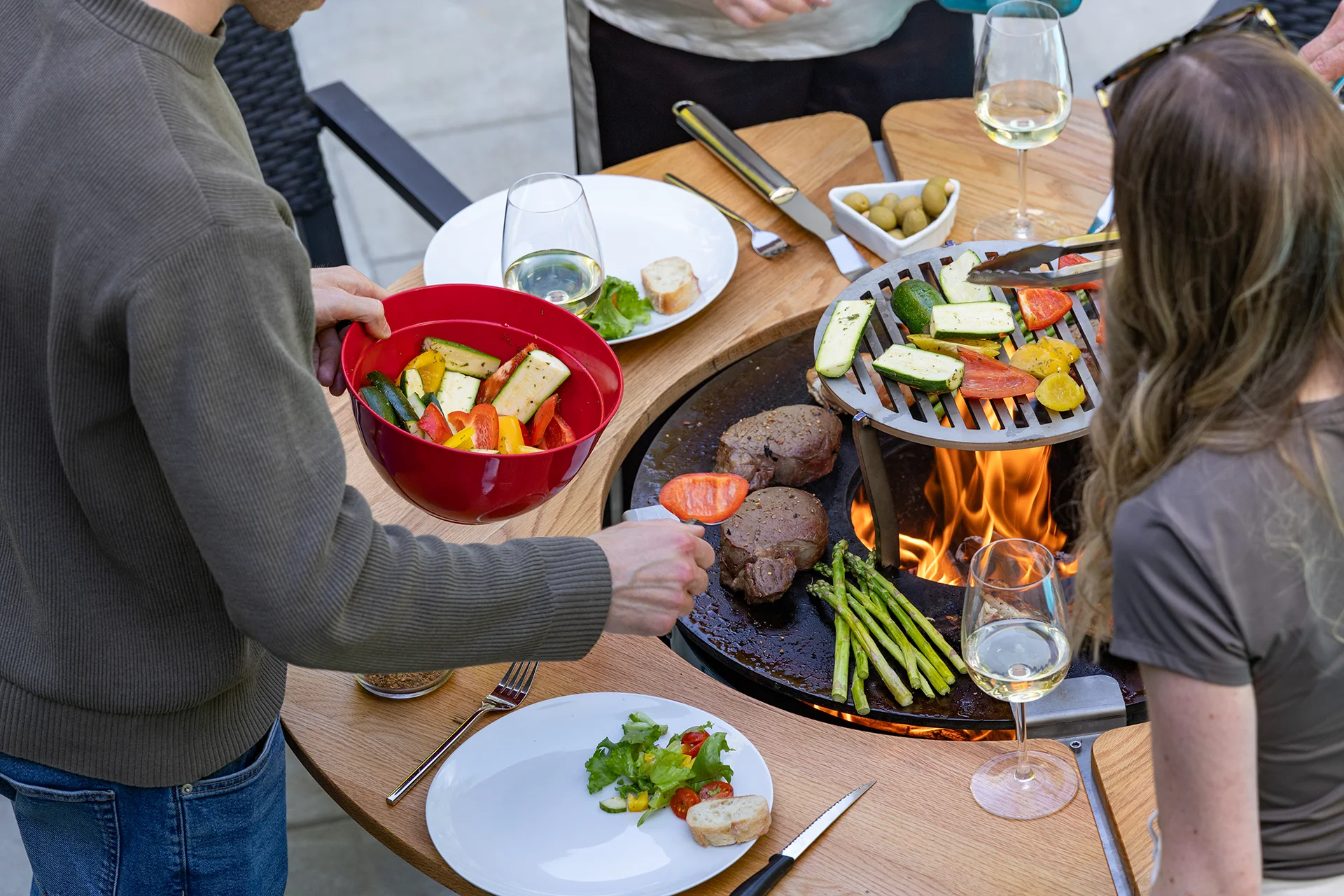 Cuisson d'aliments au feu de bois sur la plaque d’un brasero extérieur